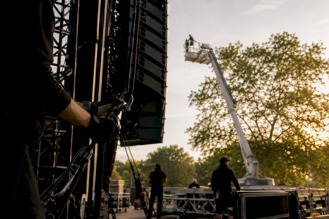 Hands adjusting outdoor music stage equipment