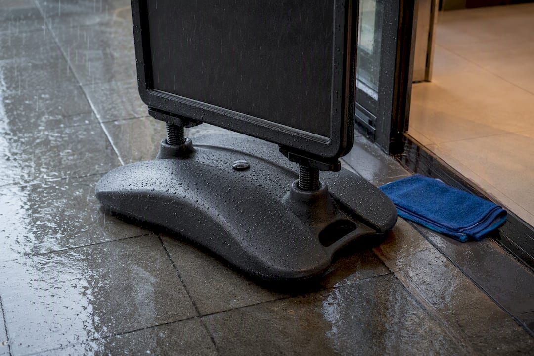 Weighted pavement sign base in rain
